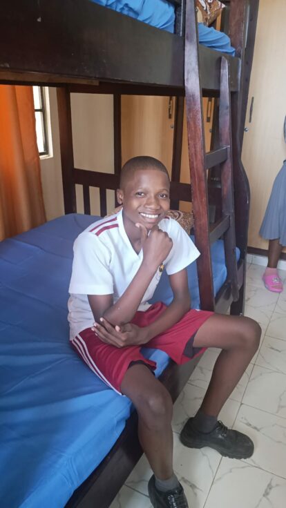 One of our student boys sitting on his bed in the safehouse