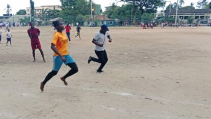 Young girl and young boy neck and neck in a barefoot race