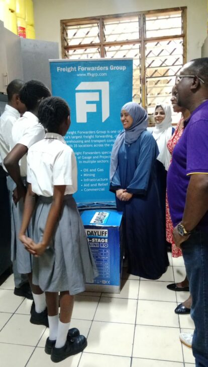 Female engineer explaining the new water purifier to a group of students