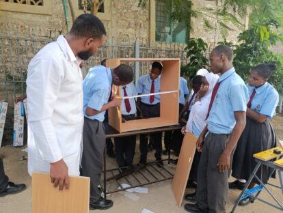 A group of students and their teacher building the bookcases for the library