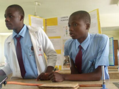 Tow of the Bombolulu senior students in front of their project board for the science show
